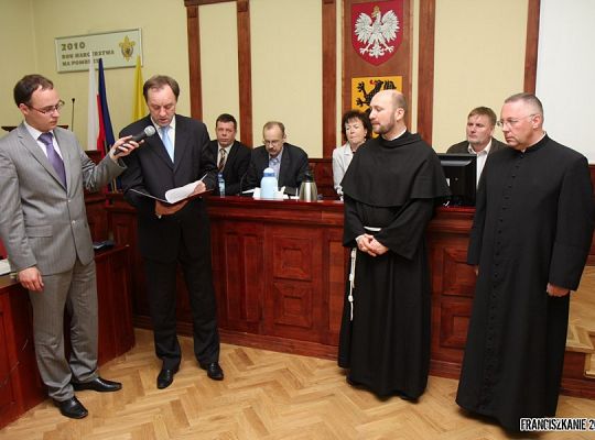 Grafika #0: Złota odznaka „Za opiekę nad zabytkami dla o. Tomasza Janka